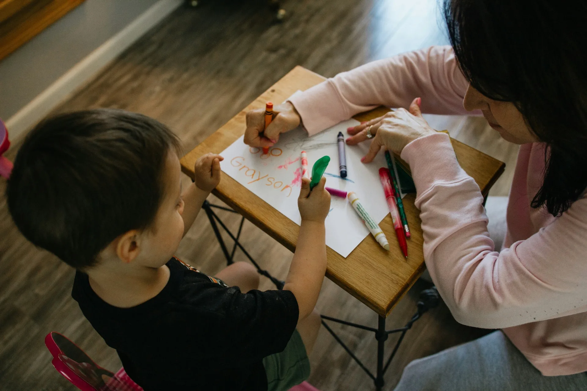 Séance d'accompagnement avec un jeune enfant autour d'une table de travail et feutres de couleur
