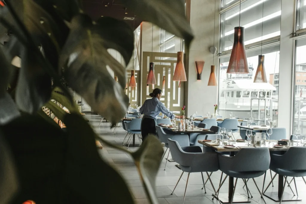 Table dressée en bois sombre dans une salle aux tons chaleureux