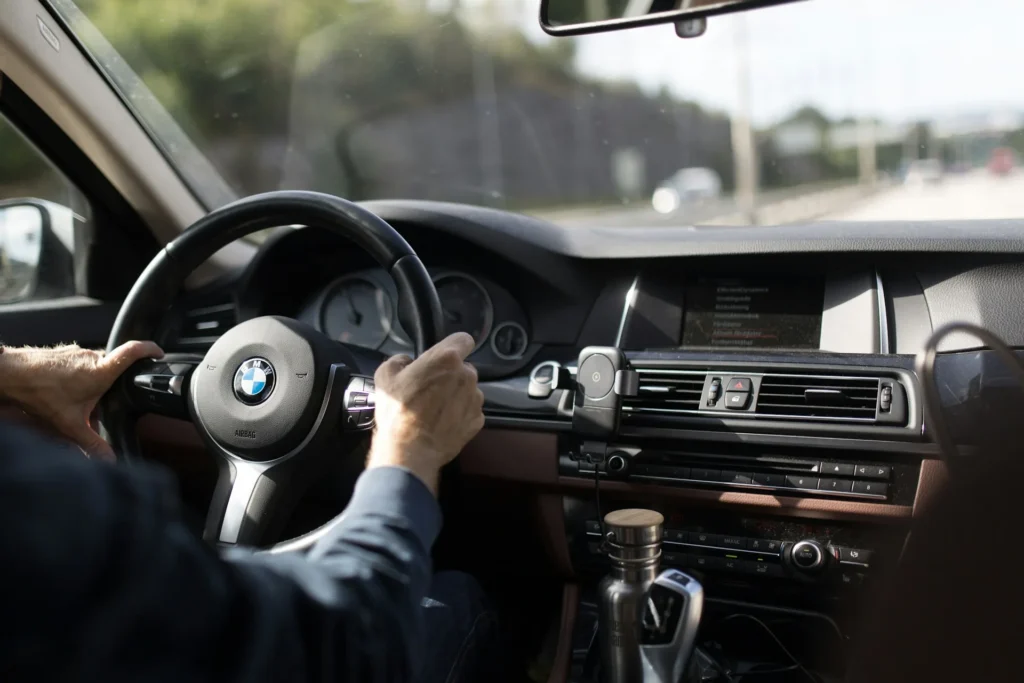 Mains gantées sur le volant d'une berline allemande haut de gamme intérieur cuir