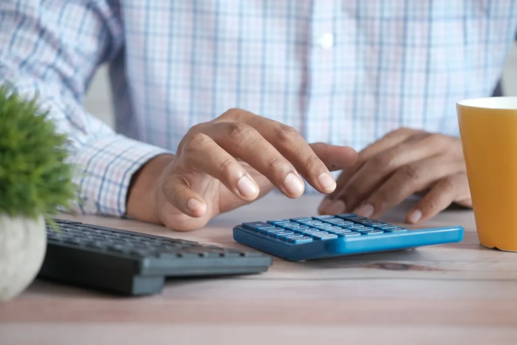 Calculatrice et budget sur un bureau, illustrant le prix d'un site internet
