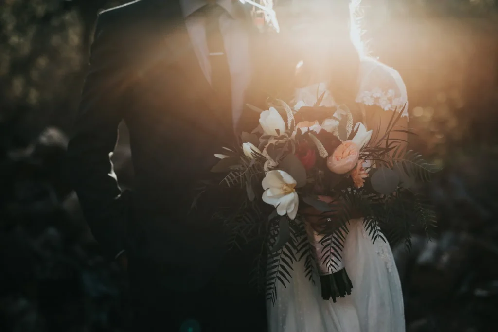 Photographe de mariage capturant un couple lors d'une séance de portrait extérieure en lumière naturelle.