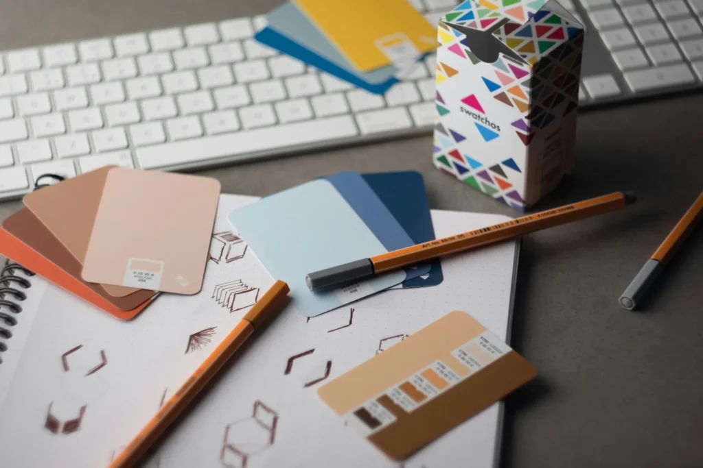 Bureau de designer avec clavier, crayons et échantillons de couleurs