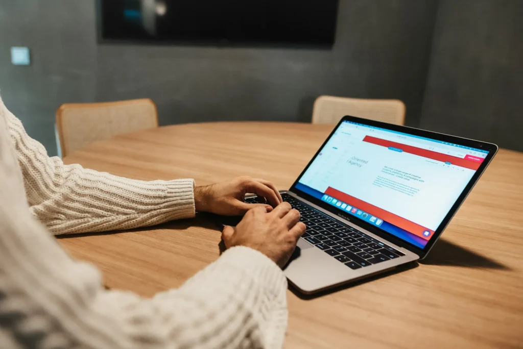 Personne créant un site sur un ordinateur portable, illustrant le choix d'un CMS